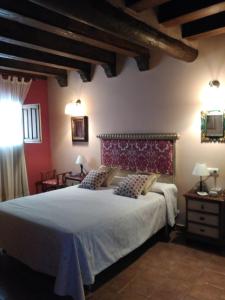 a bedroom with a large bed and a red wall at Casa Rural la Escalera in Letur