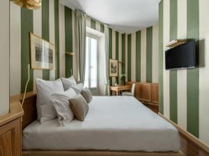 a bedroom with a bed with green and white stripes at numa l Camperio Rooms & Apartments in Milan