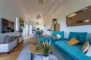 ein Wohnzimmer mit einem blauen Sofa und einem Tisch in der Unterkunft O'DYSSEE Appartement vue panoramique Bassin d'Arcachon in Pyla-sur-Mer