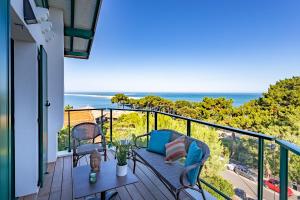 d'un balcon avec une table et des chaises donnant sur l'océan. dans l'établissement O'DYSSEE Appartement vue panoramique Bassin d'Arcachon, à Pyla-sur-Mer