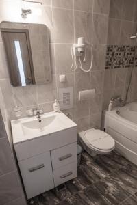 a bathroom with a sink and a toilet and a mirror at Orchid Luxury Apartment Sinaia in Sinaia