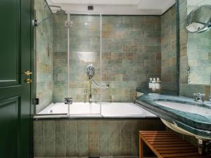 a bathroom with a bath tub and a sink at numa l Camperio Rooms & Apartments in Milan