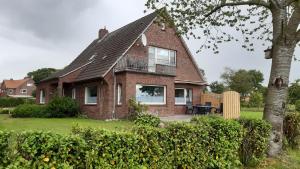 a brick house with a black roof at Ferienhaus Großheider Straße in Großheide