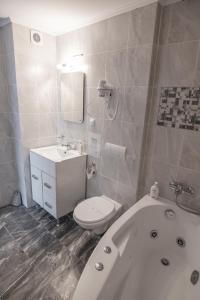 a bathroom with a tub and a toilet and a sink at Orchid Luxury Apartment Sinaia in Sinaia