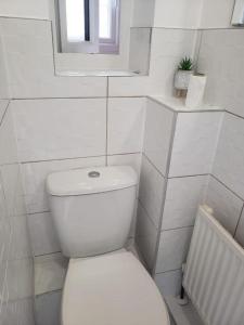 a white bathroom with a toilet and a window at Single Room only for one adult in Southall