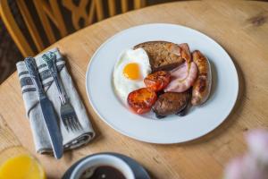 un plato de desayuno con huevos, salchichas y setas en The Exmoor Forest Inn, en Simonsbath