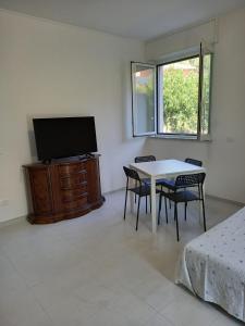 a living room with a tv and a table and chairs at A casa dalla Lu in Chiavari