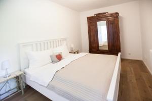 a large white bed in a room with a mirror at Kitz Apartments in Kitzbühel