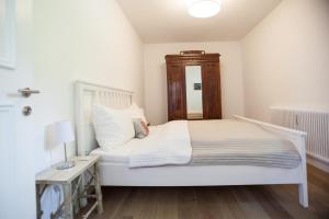 1 dormitorio con cama blanca y cabecero de madera en Kitz Apartments en Kitzbühel