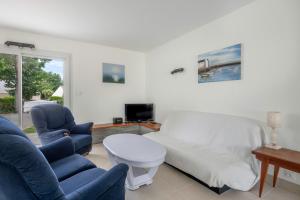 sala de estar con 1 cama, 2 sillas y TV en A deux cents metres de la mer, belle maison pour neuf personnes, en Mesquer