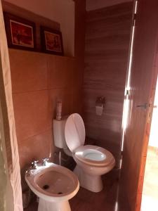 a small bathroom with a toilet and a sink at LA PALMERA in Maipú
