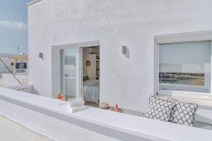 a white house with a balcony with a window at Nautica Suites-Superior Seaview suite with jacuzzi in Antiparos Town +10 photos