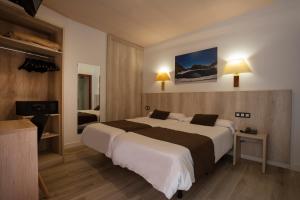 ein Hotelzimmer mit zwei Betten und einem Fernseher in der Unterkunft Hotel Marco Polo in La Massana