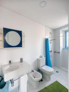 a white bathroom with a sink and a toilet at Xicotina 2 in Moledo