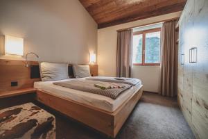 una camera da letto con un grande letto e una finestra di PRIVÀ Alpine Lodge a Lenzerheide Altre 37 foto