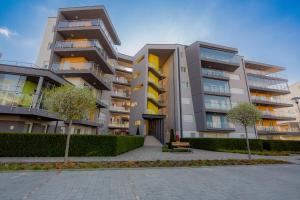 a large apartment building with trees in front of it at Admiral Luxury Stúdió Apartman By BLTN in Siófok