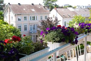 einen Balkon mit Blumen und Häusern im Hintergrund in der Unterkunft Hotel Kurfürstenhof in Bonn