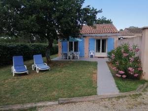 a house with two blue chairs in the yard at maison jumelée in Le Cannet-des-Maures