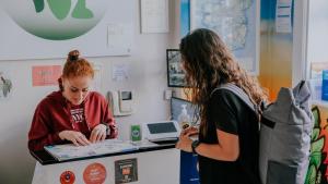 two women standing at a counter in a store at Garden Lane Backpackers in Dublin