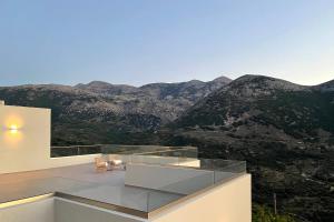 a house with a balcony with mountains in the background at Villa Aires in Vrachasi