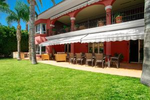 10 Bedroom 5 Star Luxury Villa & Heated Pool for 5 to 30 Guests near Alicante في موتيكْتْساميل: منتجع فيه كراسي وطاولة على عشب