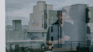 a man looking out of a window at Garden Lane Backpackers in Dublin