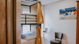 a room with a bunk bed with a table and a chair at Garden Lane Backpackers in Dublin