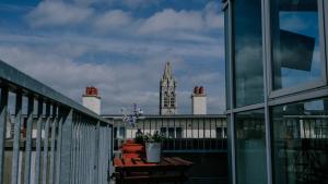 a balcony with a table with a clock tower in the background at Garden Lane Backpackers in Dublin