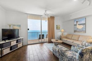a living room with a couch and a flat screen tv at Tidewater 2804 in Panama City Beach