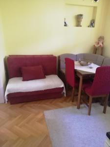 um quarto com um sofá e uma mesa e uma mesa e cadeiras em Apartman Monika Zlatar Nova Varos em Nova Varos