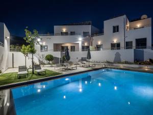a swimming pool in front of a building at night at Sunset Elafonisi Apartments in Livadia