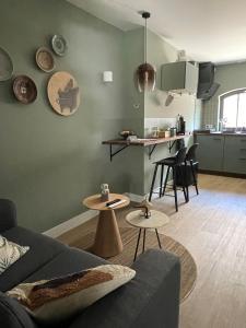 a living room with a couch and tables and a kitchen at B&B De Meije in Nieuwkoop