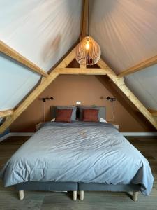 a bedroom with a large bed in a attic at B&B De Meije in Nieuwkoop