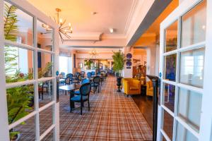 a restaurant with tables and chairs and windows at Llandudno Bay Hotel in Llandudno
