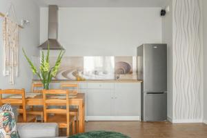 a kitchen with a table and a stainless steel refrigerator at Boho Apartment Janów z miejscem parkingowym in Łódź