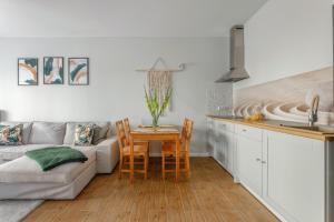 a living room with a couch and a table at Boho Apartment Janów z miejscem parkingowym in Łódź