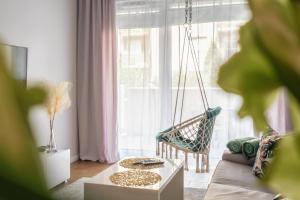 a living room with a couch and a swing in front of a window at Boho Apartment Janów z miejscem parkingowym in Łódź