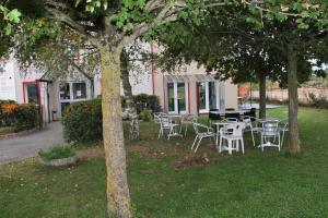 un grupo de mesas y sillas bajo árboles en un patio en Fasthotel Montereau - Esmans, en Esmans