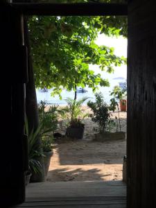 uma vista para a praia a partir de uma porta em Pousada Pé na Areia em Abraão
