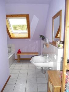 uma casa de banho com um lavatório branco e uma janela em Ferienhaus Route 5 em Elmstein
