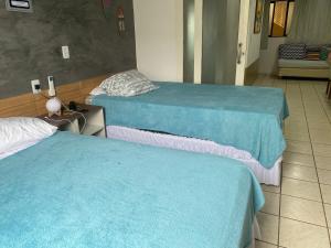 2 lits dans une salle d'hôpital avec des draps bleus dans l'établissement Atlântico Flat beira-mar, à Natal