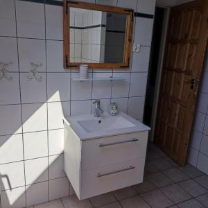 La salle de bains est pourvue d'un lavabo blanc et d'un miroir. dans l'établissement Powrócisz tu..., à Sorkwity