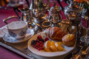 a tray with a plate of fruit and a cup of coffee at Domaine de Chalaniat in La Sauvetat