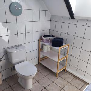 La salle de bains est pourvue de toilettes et d'une horloge murale. dans l'établissement Powrócisz tu..., à Sorkwity