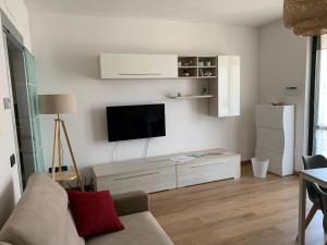 a living room with a couch and a flat screen tv at Iseo Lake apartment in Sulzano