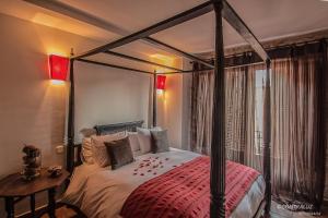 a bedroom with a four poster bed with a red blanket at La Posada De Lola in El Molar