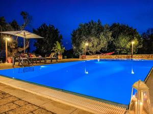a large blue swimming pool at night at Villa Scisciula Pescoluse by HDSalento in Marina di Pescoluse +15 photos