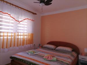 a bedroom with a bed and a window with curtains at Apartman" Ruža" in Višegrad