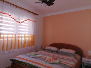 a bedroom with a bed and a window with curtains at Prenoćište " Ruža" in Višegrad