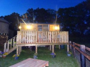 a tiny house on a deck at night at The Lazy Shepherd in East Pennard